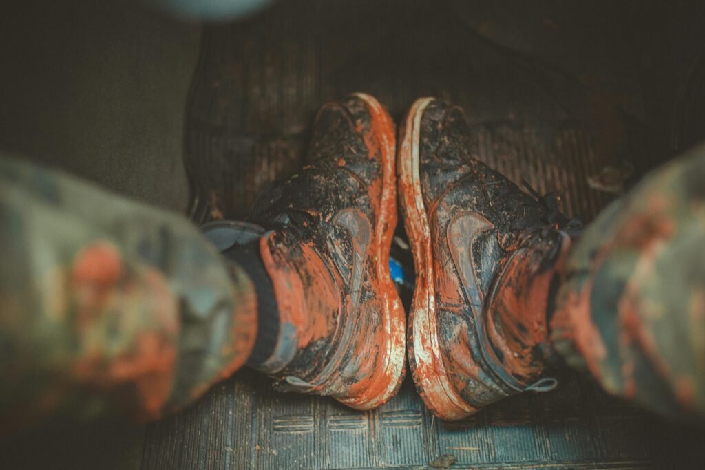 Close-up of muddy boots inside a vehicle, capturing the essence of adventure and rugged outdoor lifestyle.