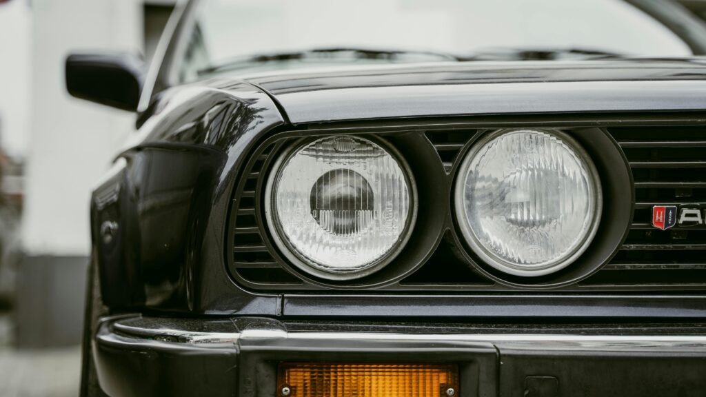 Detailed close-up of vintage BMW E30 car headlights showcasing classic design.